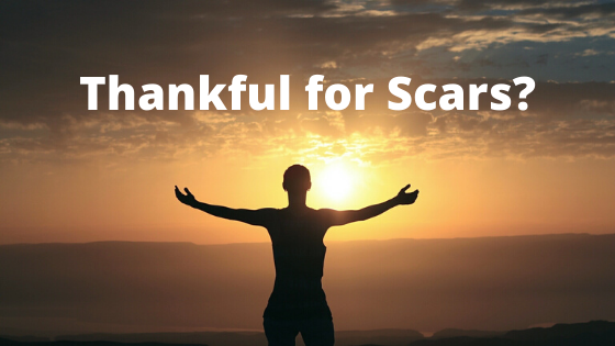 Thankful for Scars blog title with person holding out outstretched hands in background and sunset